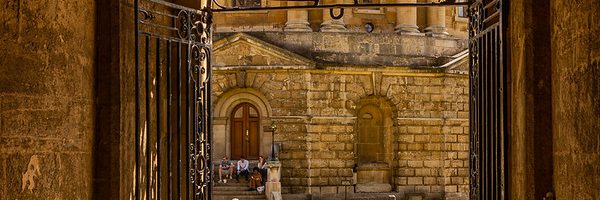 The gated passageway connecting the Radcliffe Camera to the Bodleian Quad. Image courtesy of Howard Stanbury via Flickr Commons.